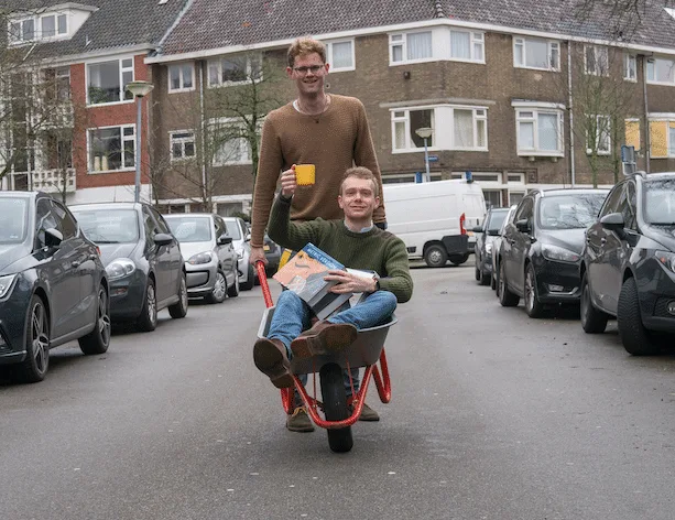 Twee docenten van Bijles Bèta met een kruiwagen